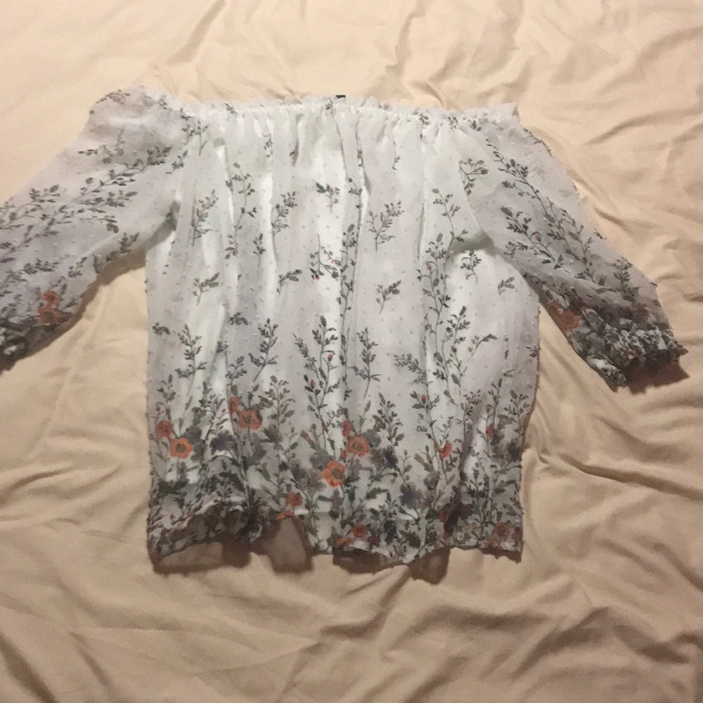 off the shoulder and has a white under shirt